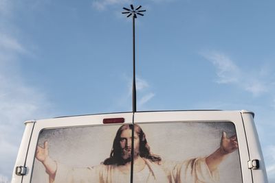 Low angle view of young woman on road against sky