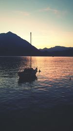 Boats in lake at sunset