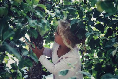 Girl standing by tree