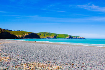 Scenic view of beach against blue sky