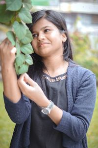 Young woman looking at leaves