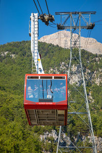 Low angle view of overhead cable car against blue sky