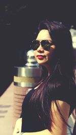 Portrait of beautiful woman wearing sunglasses at city