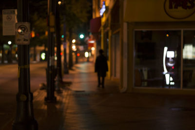 People walking on city street at night