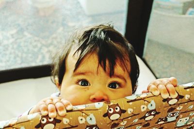 Close-up portrait of baby girl at home