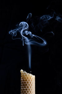 Close-up of candle against black background