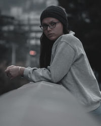 Portrait of woman standing by retaining wall