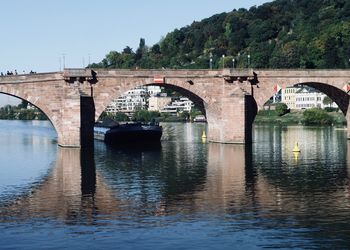 Arch bridge over river against sky