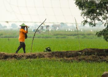 Rear view of woman standing on field