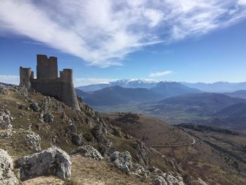 Rocca calascio on mountain peak against sky