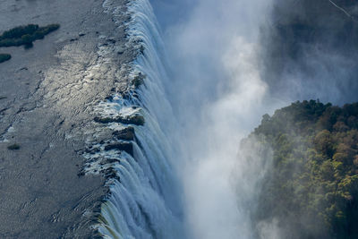 Scenic view of waterfall against sky