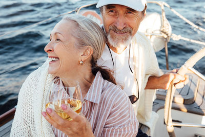 Smiling senior couple sitting on boat in sea