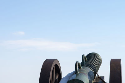 Low section of person against blue sky