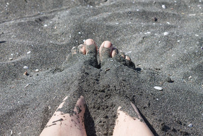 Low section of woman in sand on beach