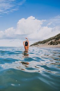 Person in sea against sky