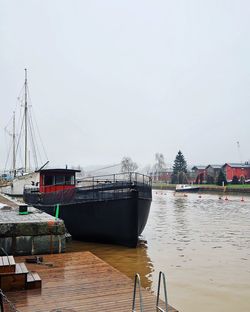 Boats moored at harbor against sky