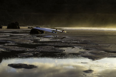 Man rowing boat in water against sky