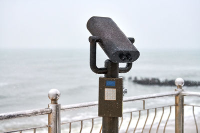 Close-up of railing against sea during winter
