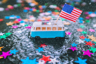 Close-up of toy with miniature american flag and colorful star shape decorations during rainfall