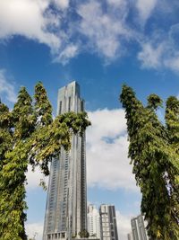 Low angle view of trees and buildings against sky