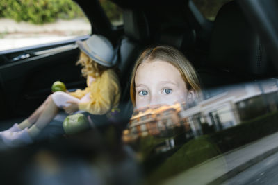 Curious girl looking through car window