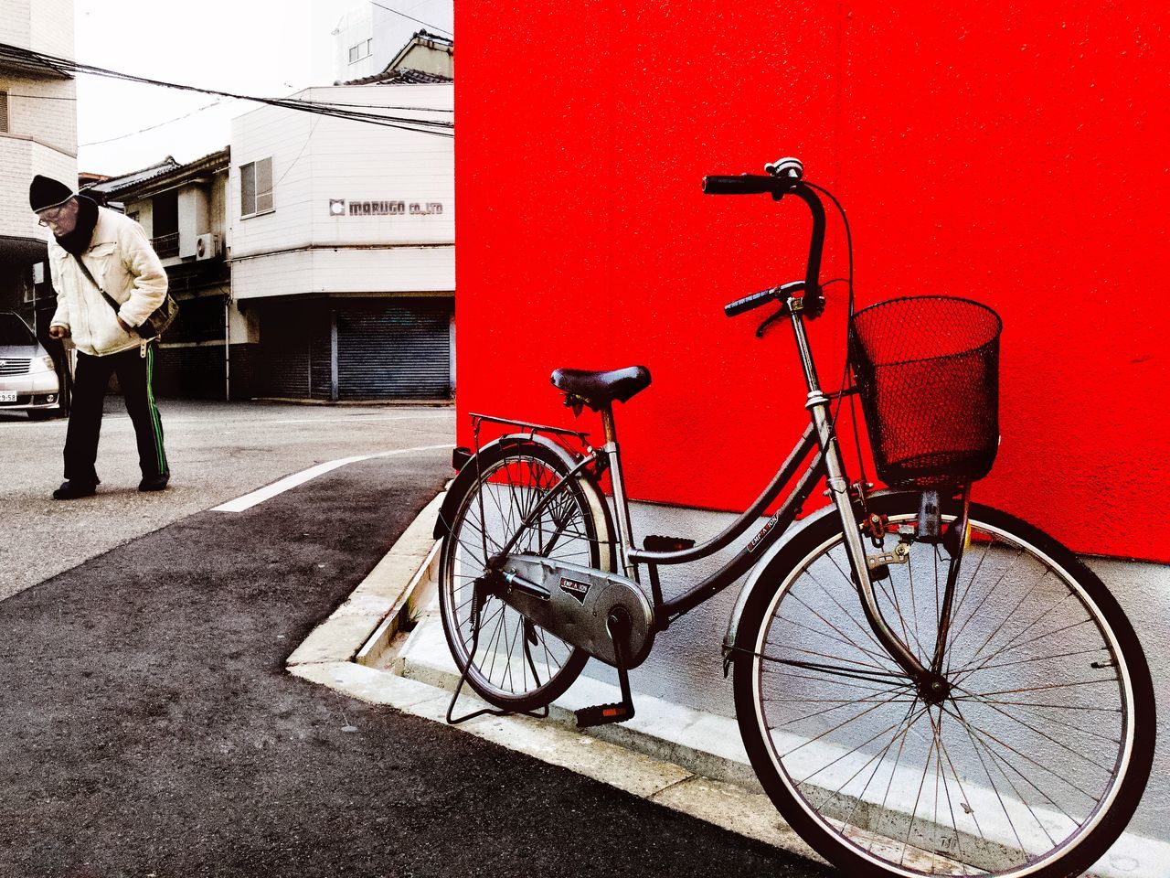 BICYCLE PARKED ON RED WALL