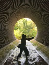 Silhouette man standing in tunnel