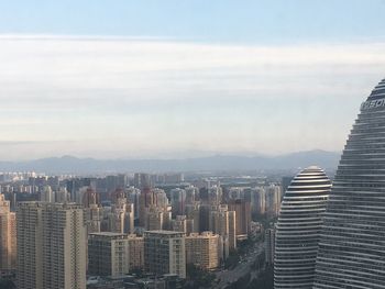 High angle view of cityscape against cloudy sky