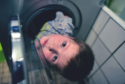 High angle portrait of boy in washing machine