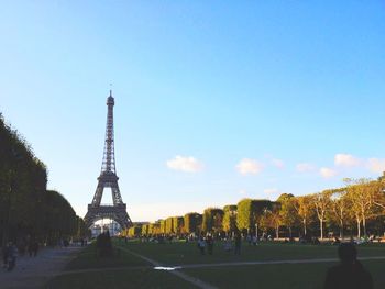 Tourists in front of building against blue sky