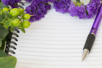 Close-up of purple flowers on blank diary