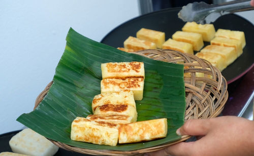 Close-up of person holding bread in plate