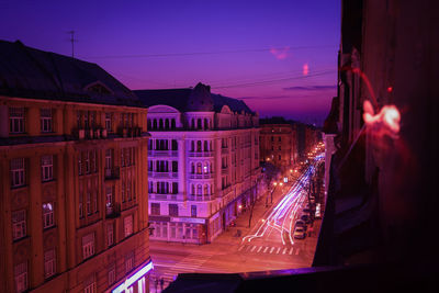 Illuminated buildings against sky at night