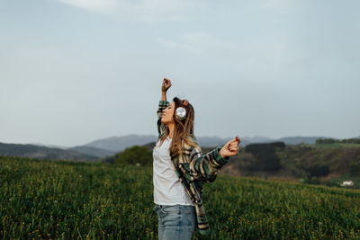 Full length of young woman standing on field