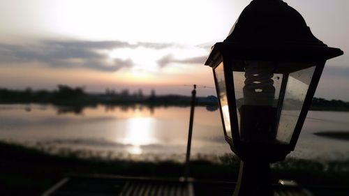 Close-up of lamp against sky at sunset