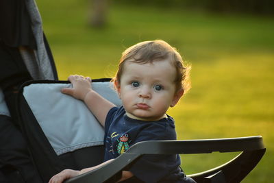 Portrait of cute baby boy in carriage at park