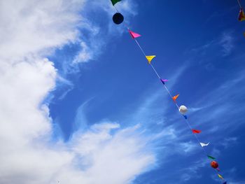 Low angle view of balloons flying against sky