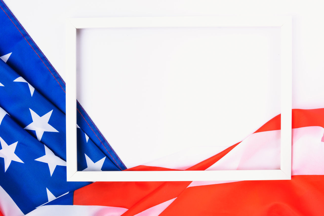 CLOSE-UP OF FLAGS AGAINST WHITE WALL