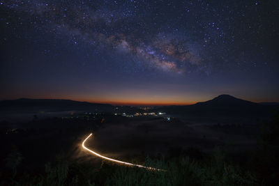 Scenic view of illuminated mountains against sky at night