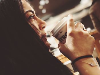 Close-up portrait of woman holding drinking glass