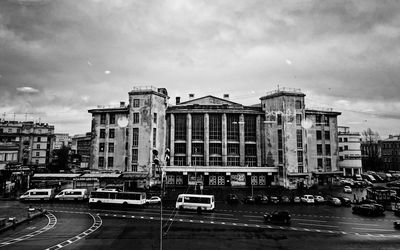 Traffic on road by buildings against sky