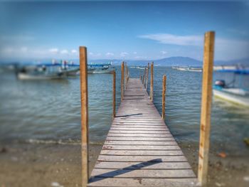 Wooden pier over sea against sky