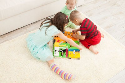 High angle view of siblings toys on floor