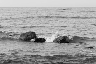 Rocks in sea against sky