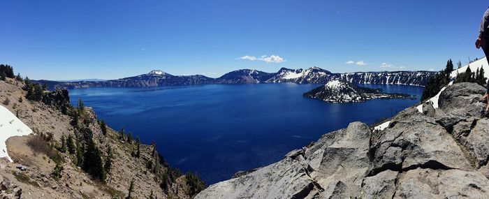 Panoramic view of sea and mountains against clear blue sky