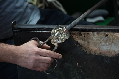 Close-up of hands cutting glass in factory