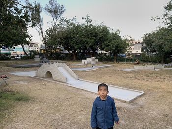 Portrait of boy standing against trees