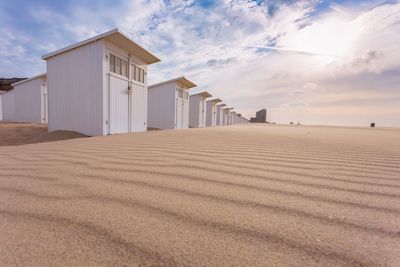 Beach houses on sand against sky