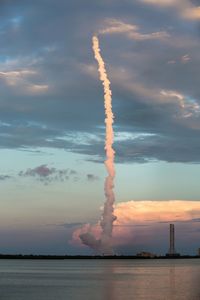 Low angle view of rocket taking off against sky