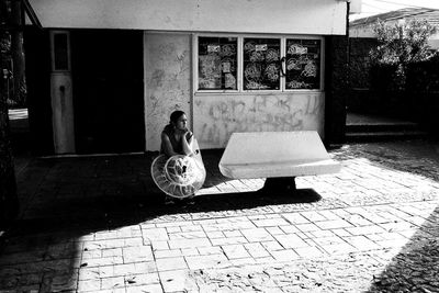 Full length of woman sitting on bench